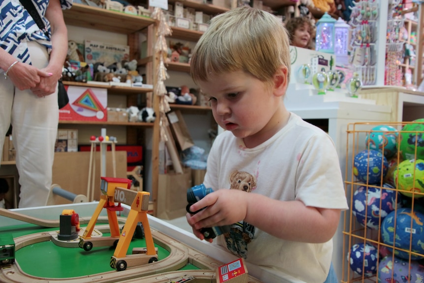 Child plays with trains in a toy shop