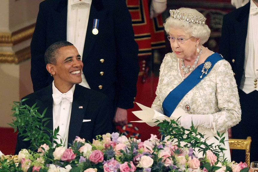 Barack Obama smiles as Queen Elizabeth II speaks at Buckingham Palace.