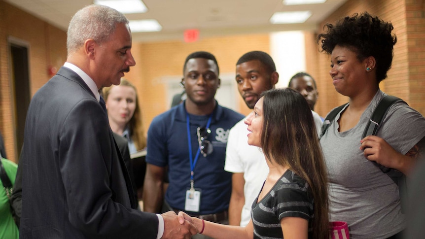 US Attorney-General Eric Holder shakes hands with student Bri Ehsan after a meeting in Ferguson, Missouri.