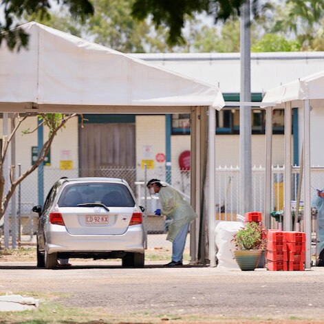 A nurse wearing PPE tests a Katherine resident for Covid-19 at a drive through clinic.