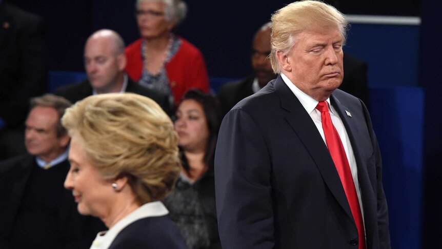 Republican presidential nominee Donald Trump, right, and Hillary Clinton listen to a question.