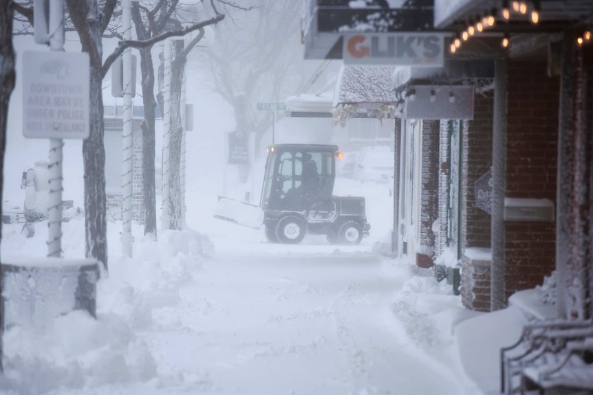 City crews clear snowy sidewalks in empty downtown St Joseph, Michigan.
