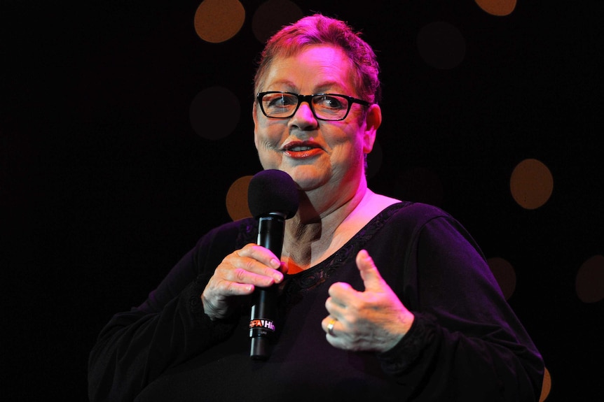Jo Brand on stage holding a microphone