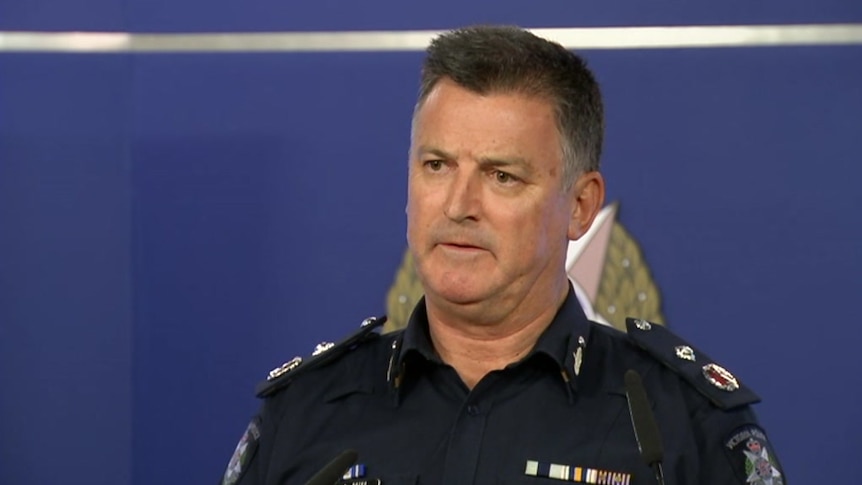 Acting Deputy Commissioner Robert Hill  wearing a blue police uniform.