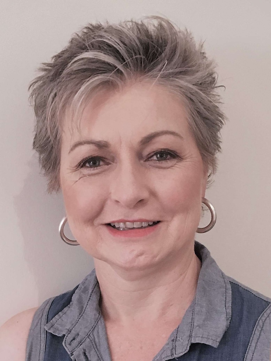 A lady with short hair and large ear rings.