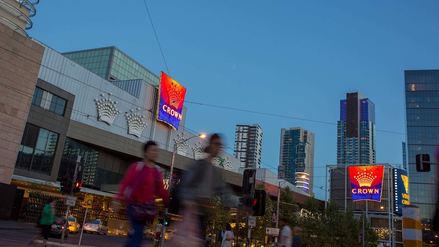 People walk in front of the Crown Casino building in Melbourne.