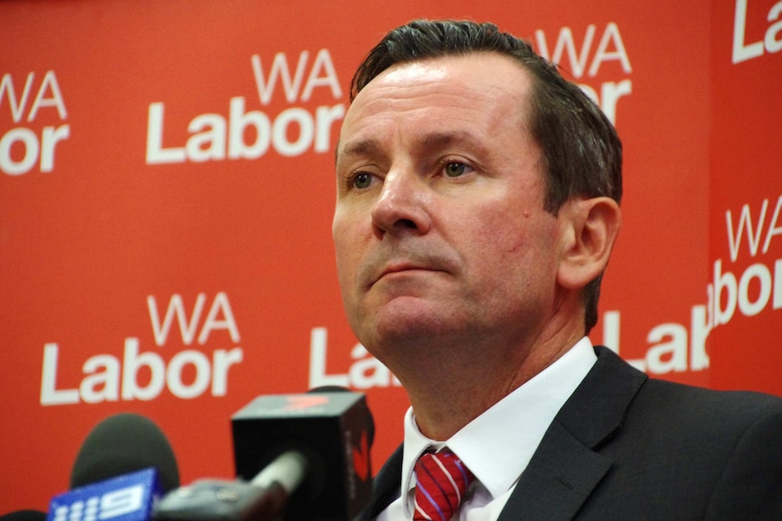 WA Labor Leader Mark McGowan speaks during a media conference in front of a red WA Labor backdrop.