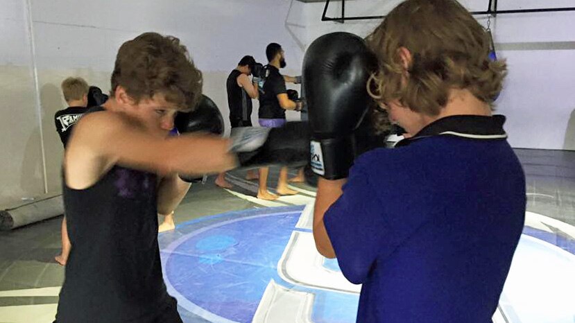 youths doing boxing, self-defence in a gym