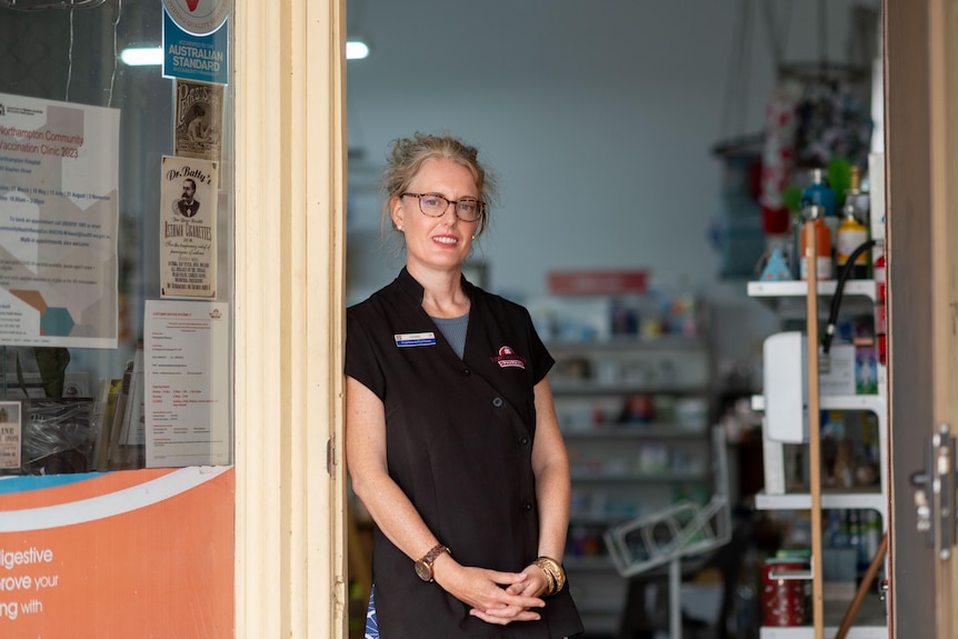 Woman standing in the doorway of a pharmacy. 