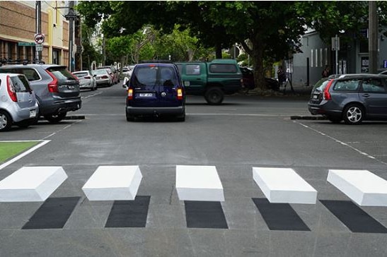A road with the effect of a raised pedestrian crossing.