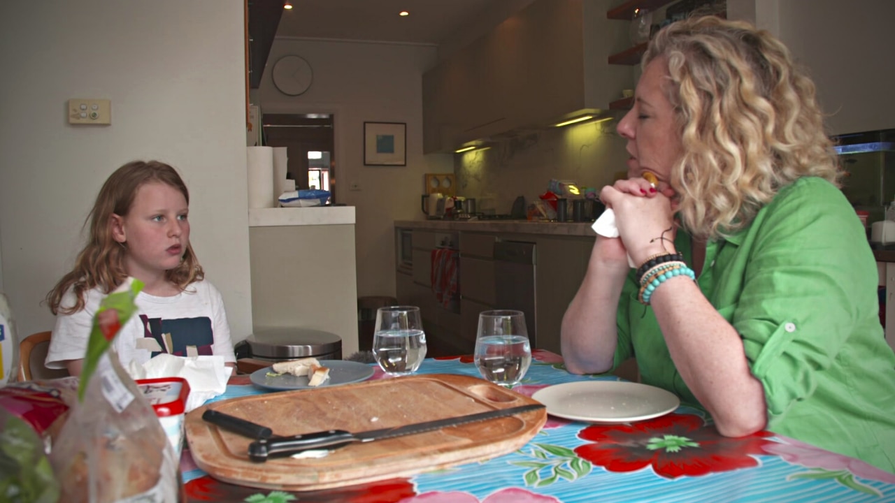Mother and daughter sitting at a dining table.