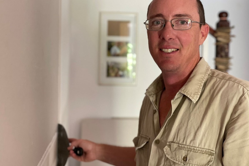 Cameron Wellsteed, who owns a Gladstone carpentry business, works on a wall in a home.