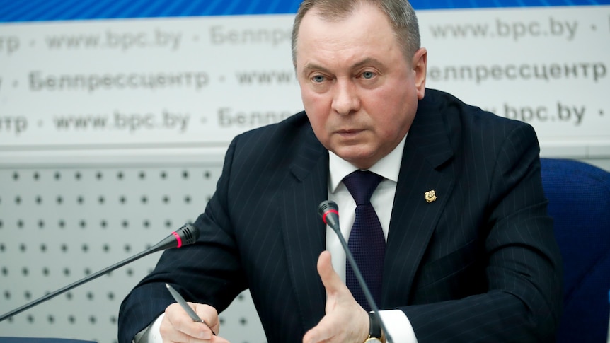 Vladimir Makei seated in front of microphones