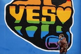 Men walks past 'Yes' graffiti in Dublin