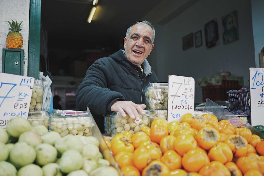Niseem Hikushlern smiles in his fruit shop owner in the Mahanay Yehuda market