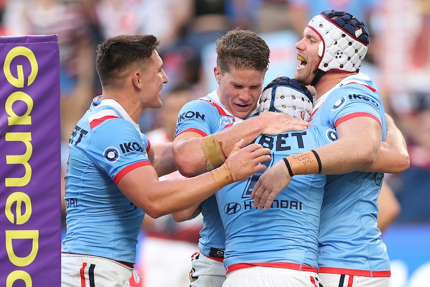 A bunch of footballers hug a teammate