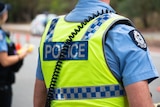 A generic photograph of an unidentified WA Police officer wearing a high visibility police vest over a blue uniform.