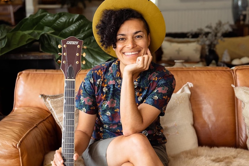 mujer sentada, con, guitarra, sonriente