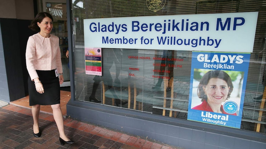 A woman walks near a shopfront.