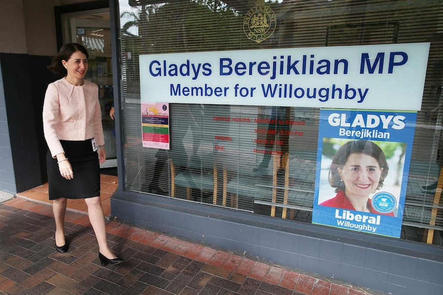 A woman walks near a shopfront.