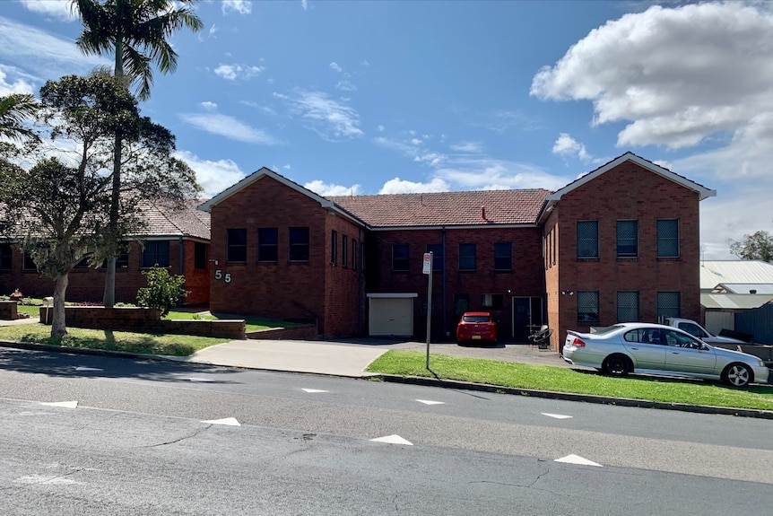 A brick building with cars out front.