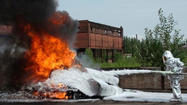 Fire fighter sprays foam on a fire