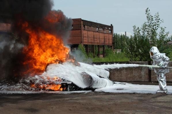 Fire fighter sprays foam on a fire