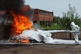 Fire fighter sprays foam on a fire