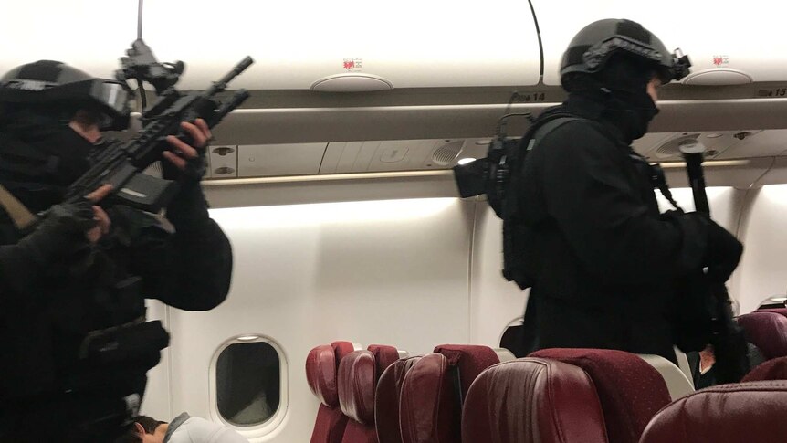 Two heavily armed police officers walk down the aisle of a Malaysia Airlines plane.