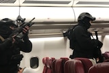 Two heavily armed police officers walk down the aisle of a Malaysia Airlines plane.