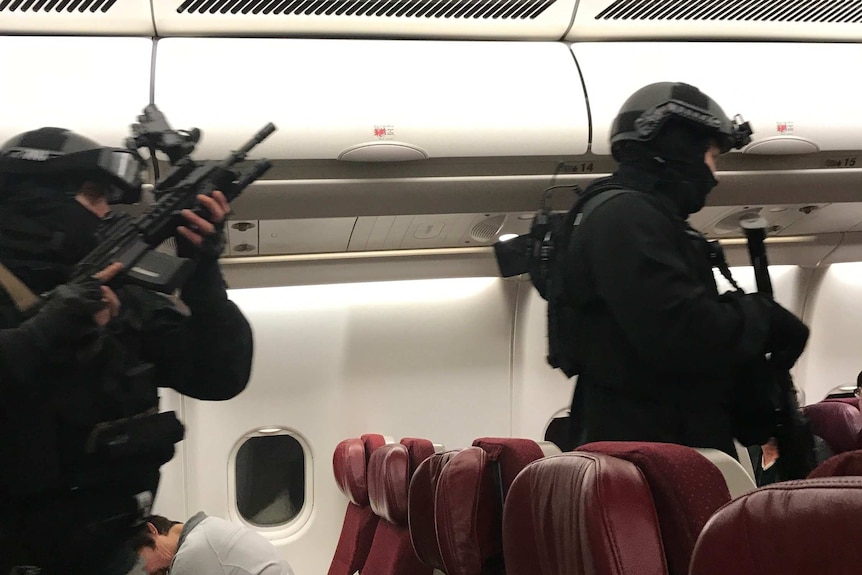 Two heavily armed police officers walk down the aisle of a Malaysia Airlines plane.