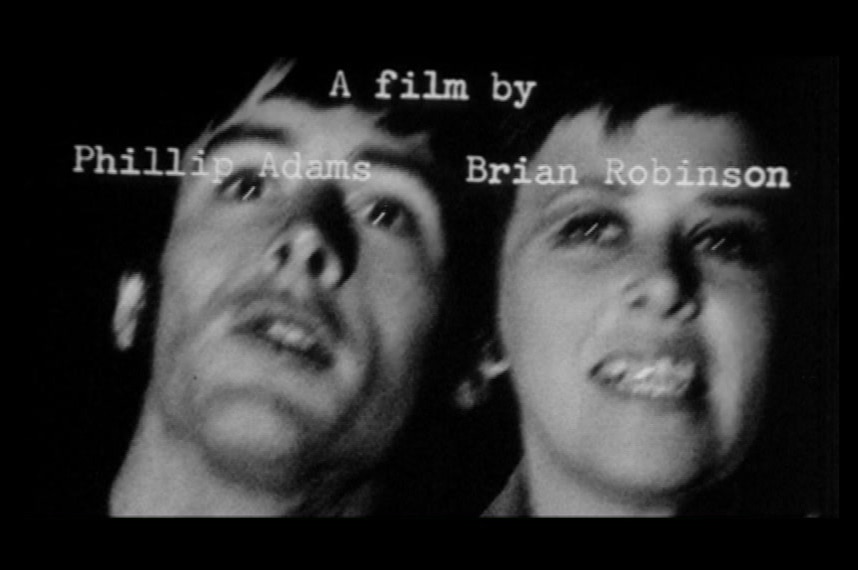 Black and white still of man and woman's faces from opening titles with "A film by Phillip Adams Brian Robinson" on screen.