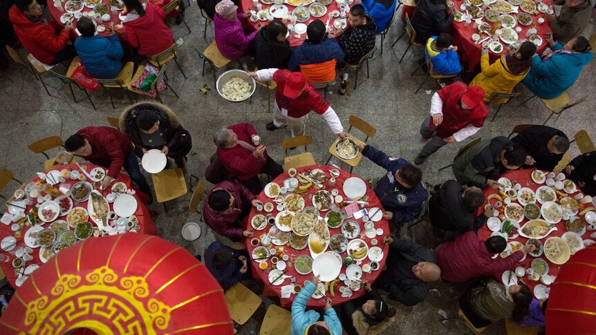 A waiter serves up dumplings on the eve of Chinese New Year during a large feast.