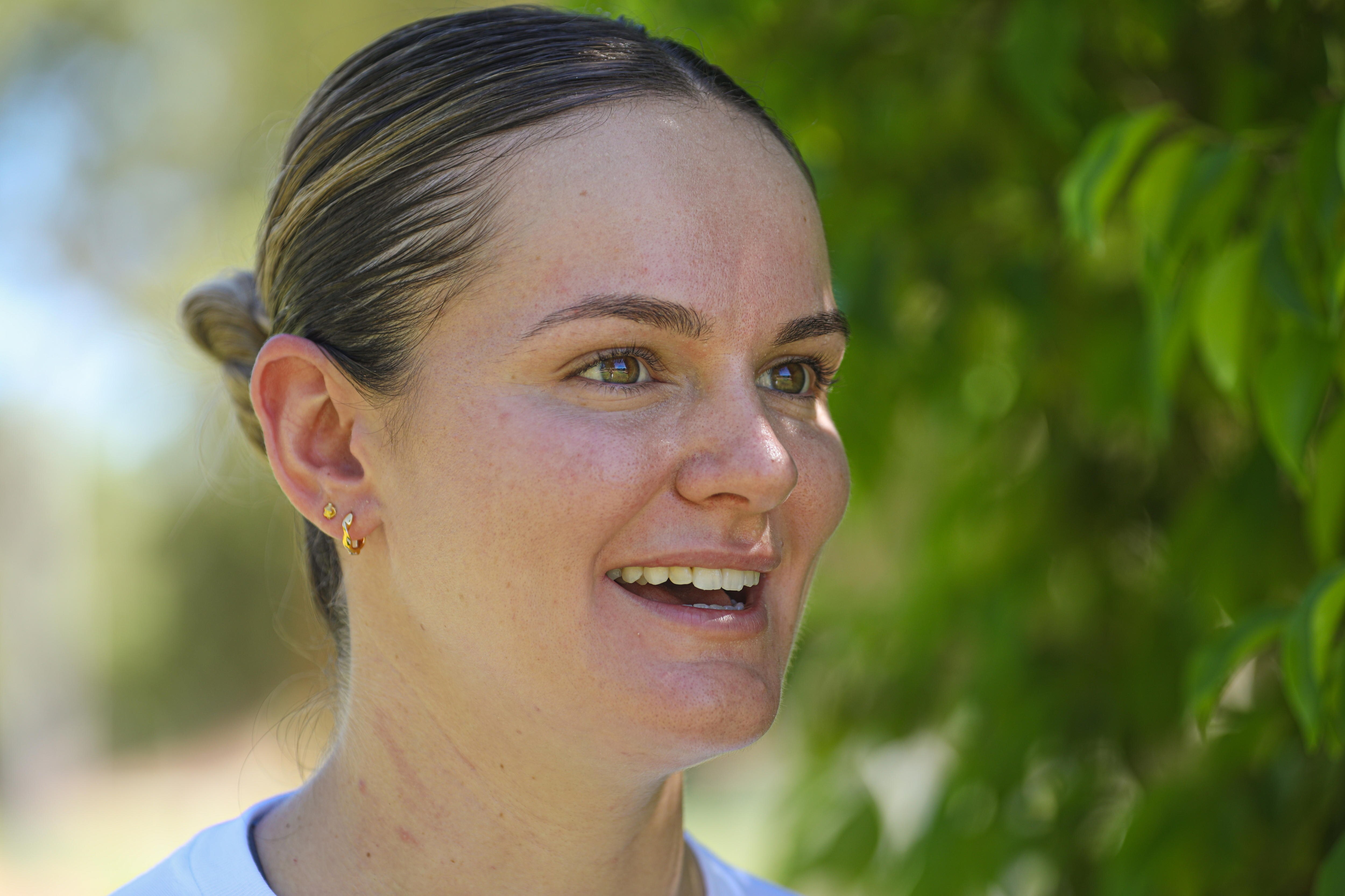 A close-up of a young woman talking as she stares off into the distance