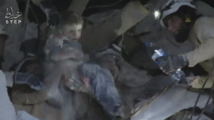 Syrian Civil Defence workers rescue a child from the rubble