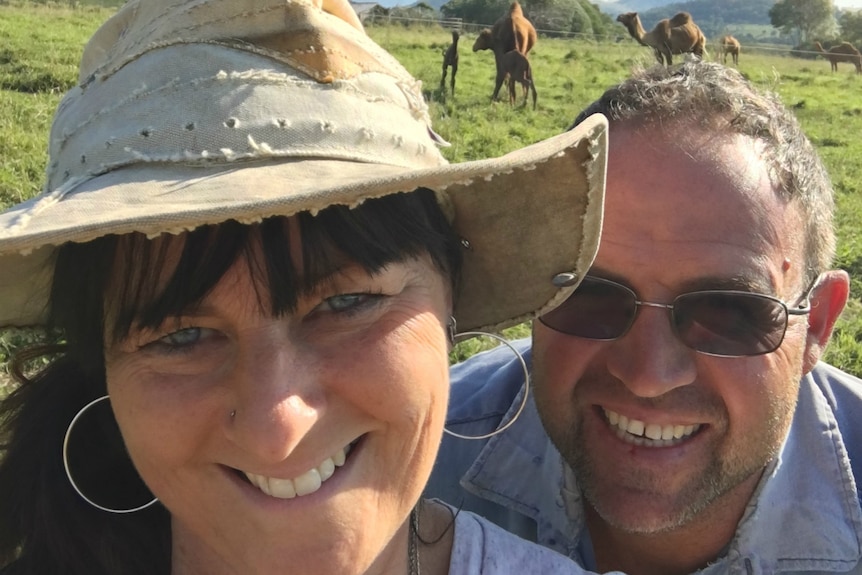 Melanie Fitzgibbon and Wayne Morris take a selfie in front of camels.
