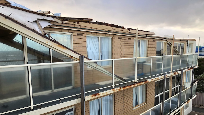 Apartment block missing part of its roof.