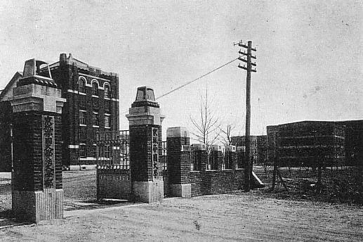 An old photograph depicts the entrance of a western looking building