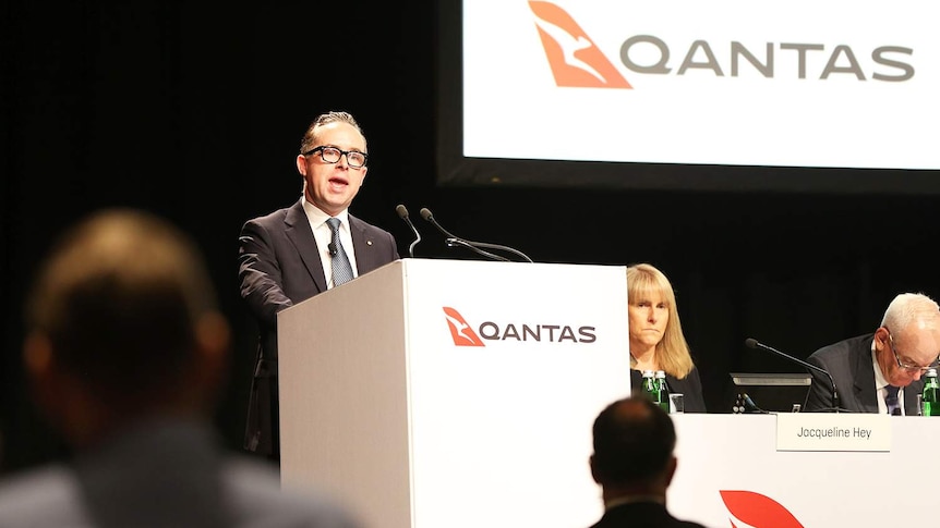 Qantas chief executive officer Alan Joyce speaks at a lectern at the company annual general meeting, held in Brisbane.