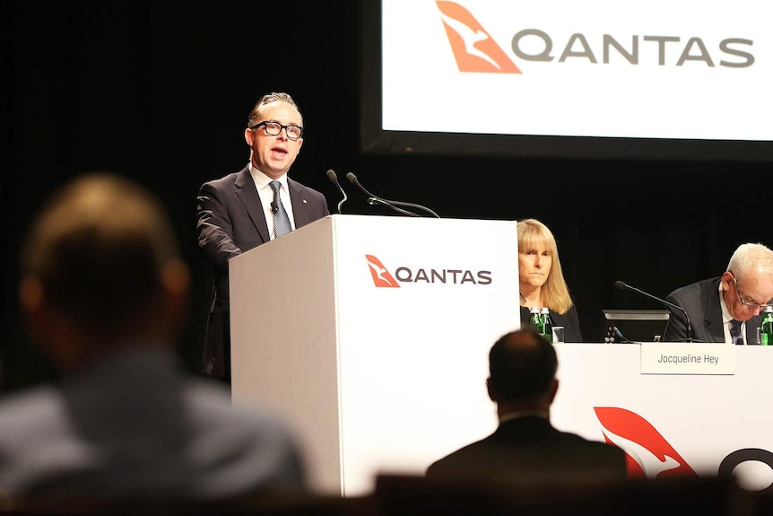 Qantas chief executive officer Alan Joyce speaks at a lectern at the company annual general meeting, held in Brisbane.