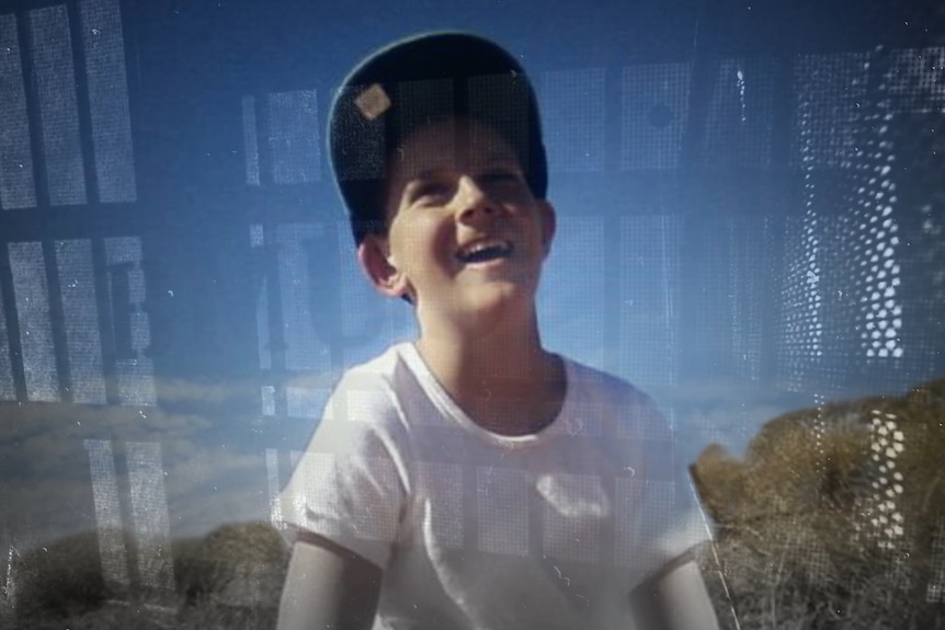 A photo of a young Dylan Voller smiling, wearing a white shirt and a baseball cap.