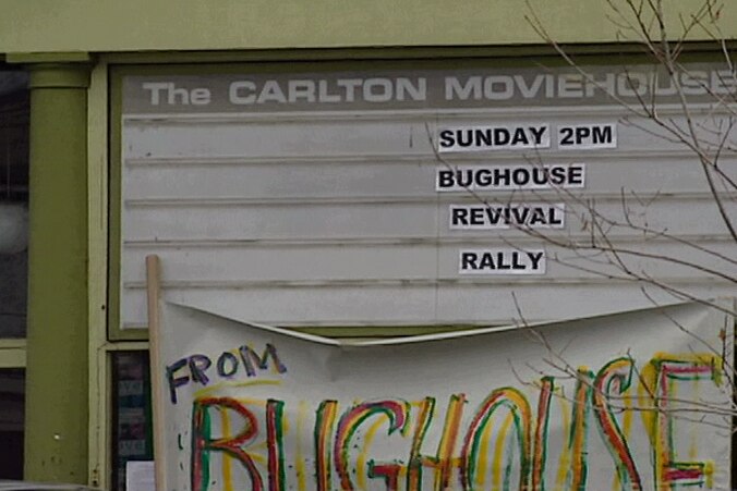 An outdoor shot of a green-painted Carlton Movie House building, with movie listings sign saying 'Sunday 2PM, Bughouse Revival'.
