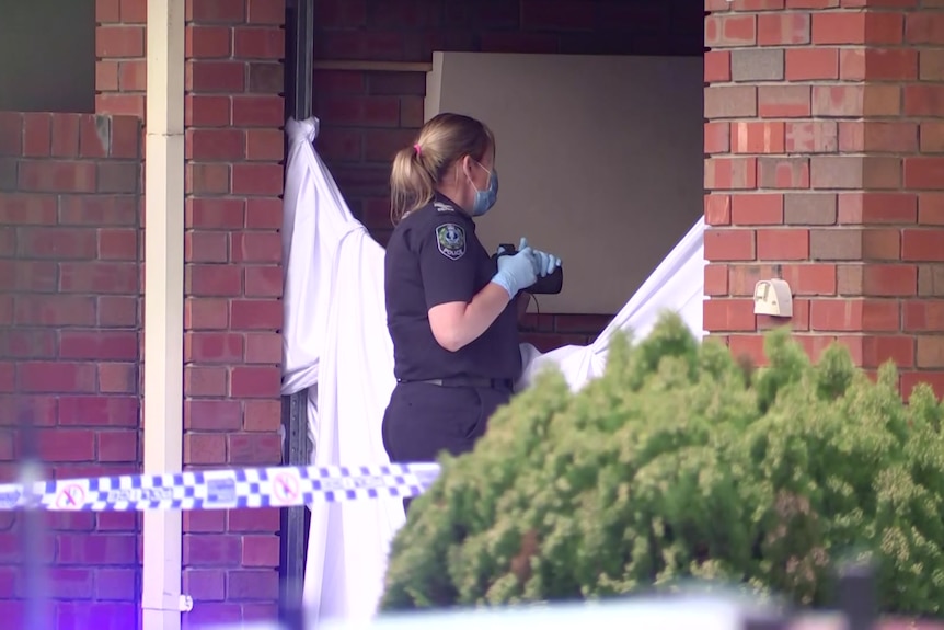 A female police officer with a camera in a doorway