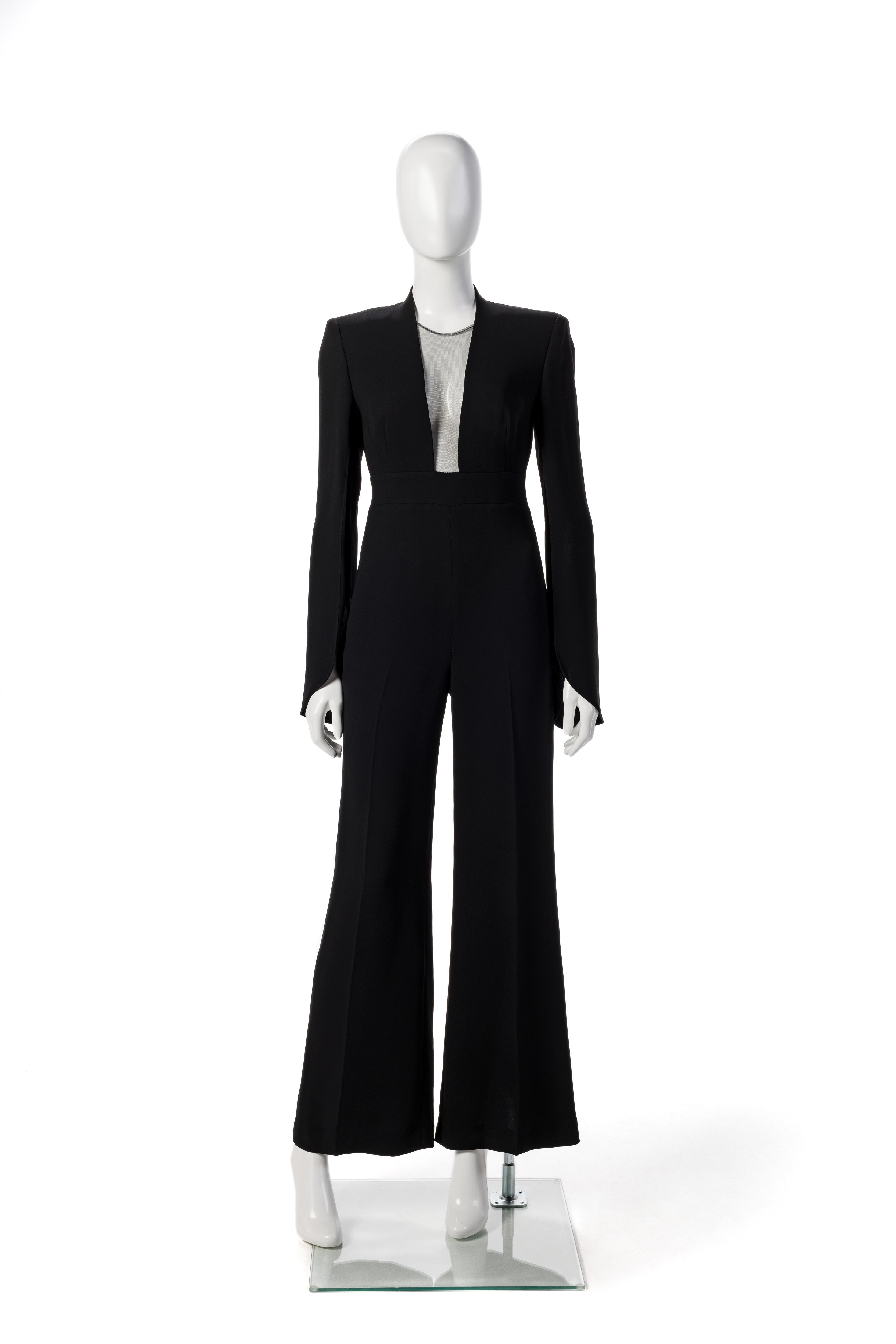 A white mannequin is dressed in a long-sleeved black jumpsuit with a plunging neckline.