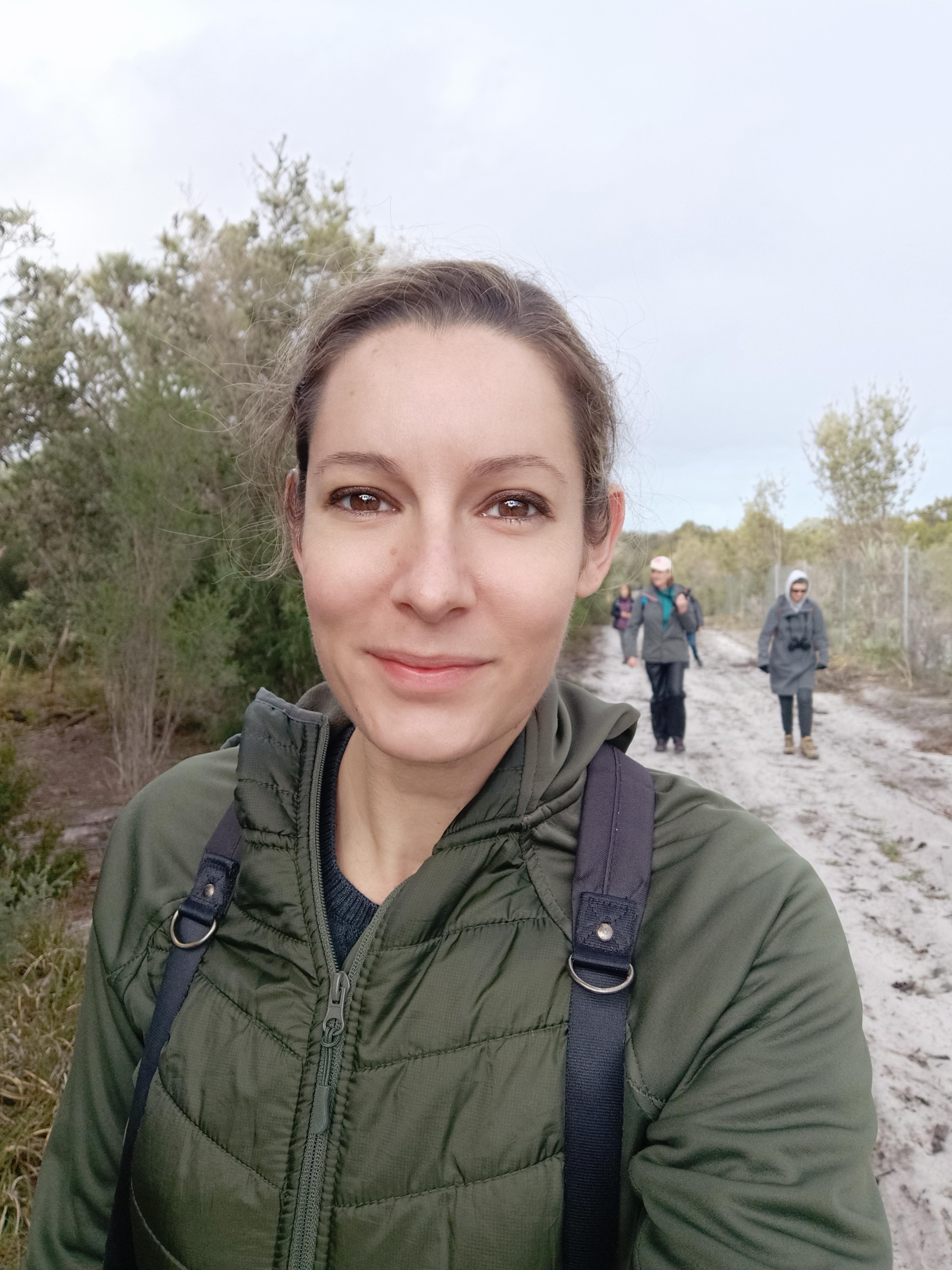 A selfie taken by Rochelle Steven while walking in the bush with other people on the trail behind her