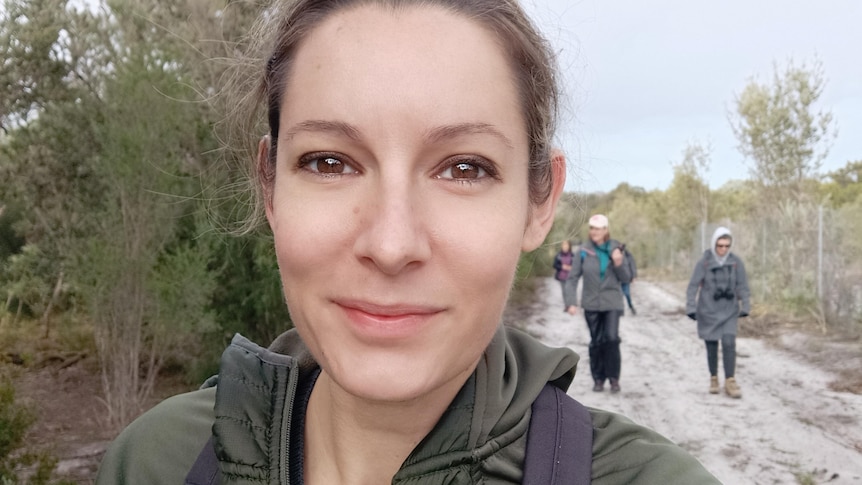 A selfie taken by Rochelle Steven while walking in the bush with other people on the trail behind her