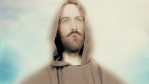 soft focus footage of an AI men with a scruffy beard in a brown hooded clock