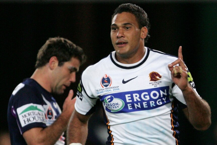 Brisbane Broncos' Justin Hodges points to the sky. Melbourne Storm's Cameron Smith is behind him.