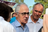 Close-up of Malcolm Turnbull speaking as John Alexander watches on.