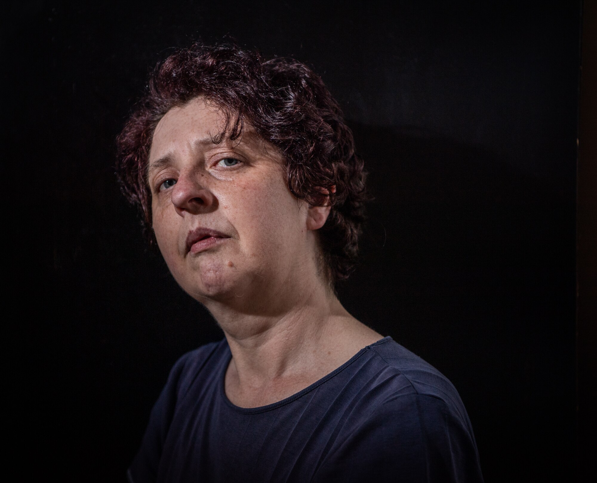 A headshot of a woman with a black background